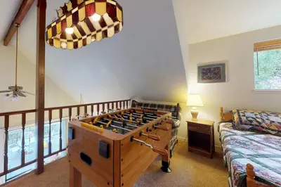 a room with a foosball table in front of a bed at Cozy Chalet (15-013) in Groveland