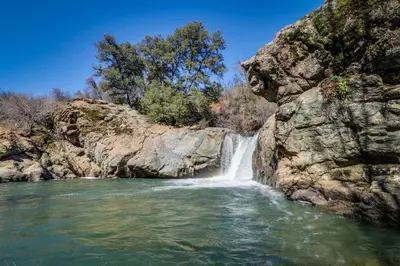 a waterfall on a river next to a rocky cliff at Cozy Chalet (15-013) in Groveland