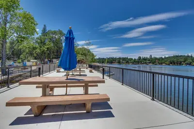 a blue umbrella sitting on a bench next to the water at Lake Lodge Beach (04-040) in Groveland