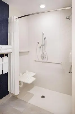 a white bathroom with a shower and a sink at Fairfield Inn & Suites by Marriott Fresno North/Shaw Avenue in Fresno