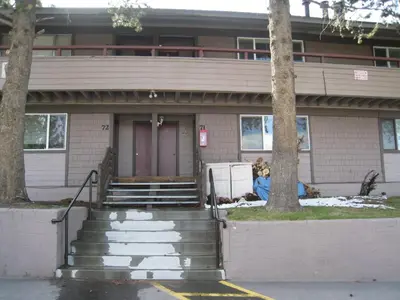 a house with stairs and a door with a dog in front at Sierra Manor in Mammoth Lakes