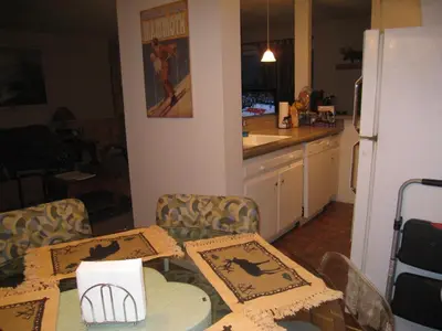 a kitchen with a table and chairs and a refrigerator at Sierra Manor in Mammoth Lakes