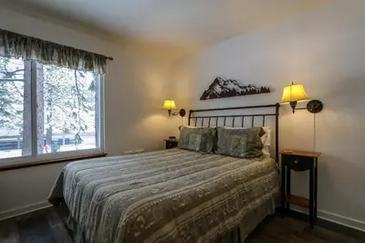 a bedroom with a large bed and a window at Sunshine Village 104 Condo in Mammoth Lakes