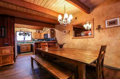 a dining room with a wooden table and a kitchen at Winterset 12 Condo in Mammoth Lakes