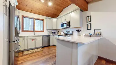 a kitchen with white cabinets and a wooden ceiling at Winterset 12 Condo in Mammoth Lakes