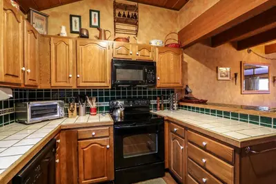 a kitchen with wooden cabinets and a black stove top oven at Winterset 12 Condo in Mammoth Lakes