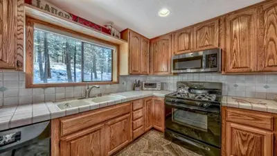 a kitchen with wooden cabinets and a sink and a window at Your Roomy Northstar Retreat Awaits in Truckee