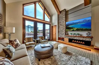 a living room with a fireplace and a large window at Luxury Three Bedroom Residence Steps From Heavenly Village Condo in South Lake Tahoe