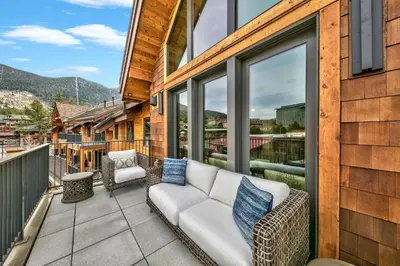 a patio with a couch and chairs on a balcony at Luxury Three Bedroom Residence Steps From Heavenly Village Condo in South Lake Tahoe