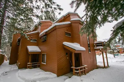 a wooden house with snow on the roof at Woodlands #33 Condo in Mammoth Lakes