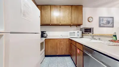 a kitchen with wooden cabinets and a white refrigerator at Summit Condominium #273 Condo in Mammoth Lakes