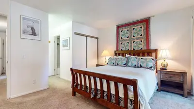 a bedroom with a large wooden bed in a room at Summit Condominium #273 Condo in Mammoth Lakes