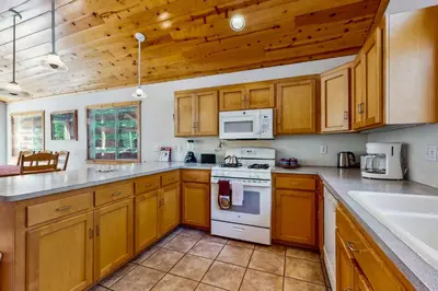 a kitchen with wooden cabinets and white appliances at Happy Family Cozy Cabin in Truckee