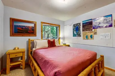 a bedroom with a wooden bed and a window at Happy Family Cozy Cabin in Truckee