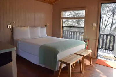 a bedroom with a large bed and a balcony at Yosemite RV Resort in Coarsegold