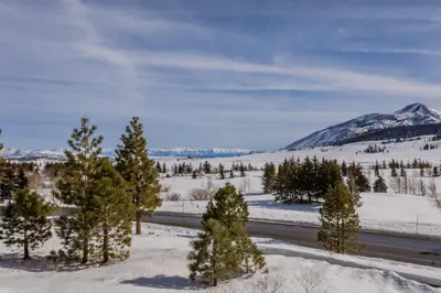 a road in the snow with a mountain in the background at Creekhouse 1320 in Mammoth Lakes