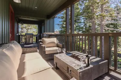 a screened in porch with a couch and a coffee table at Creekhouse 1320 in Mammoth Lakes