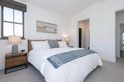 a white bedroom with a large bed and a window at Creekhouse 1320 in Mammoth Lakes