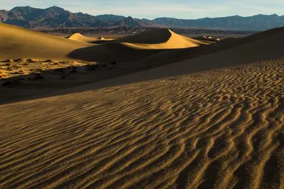 a desert with sand dunes and mountains in the background at The Ranch At Death Valley in Death Valley