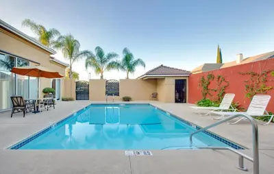 a swimming pool with two chairs and a table at Holiday Inn Express Oakdale by IHG in Oakdale