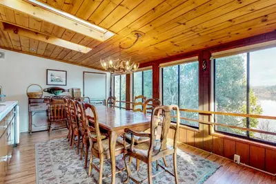 a dining room with a table and chairs and windows at Heart's Desire on the Lake (01-275) in Groveland