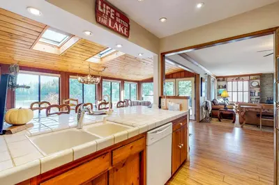 a kitchen with a sink and a living room at Heart's Desire on the Lake (01-275) in Groveland