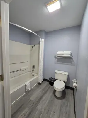 a bathroom with a toilet and a tub and a sink at Quality Inn & Suites Tulare in Tulare