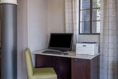 a desk with a computer and a printer and a chair at La Quinta Inn by Wyndham Sacramento North in Sacramento