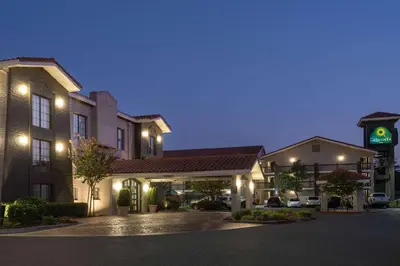 a hotel building with a clock tower at night at La Quinta Inn by Wyndham Sacramento North in Sacramento