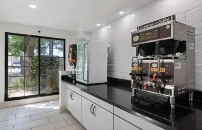 a kitchen with a black counter top with a machine at La Quinta Inn by Wyndham Stockton in Stockton
