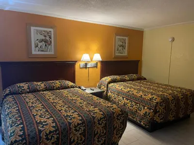 a hotel room with two beds and two lamps at Kings Rest Motel in Lemoore