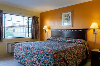 a hotel room with a bed and a window at Kings Rest Motel in Lemoore