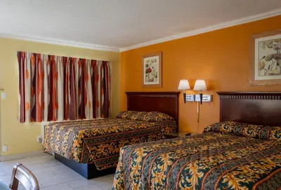 a hotel room with two beds and a window at Kings Rest Motel in Lemoore