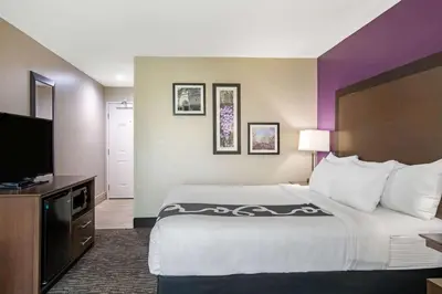 a hotel room with a large bed and a flat screen tv at La Quinta by Wyndham Visalia/Sequoia Gateway in Visalia