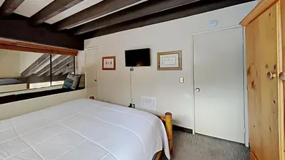 a bedroom with a large white bed and a window at Warm and Cozy 4 Bedroom Condo in Mammoth! in Mammoth Lakes
