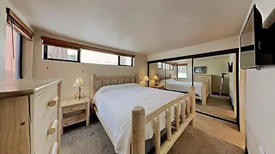 a bedroom with a large bed and a mirror at Warm and Cozy 4 Bedroom Condo in Mammoth! in Mammoth Lakes