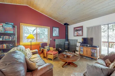 a living room with a leather couch and a table at Serventi Tahoe Donner Cabin in Truckee