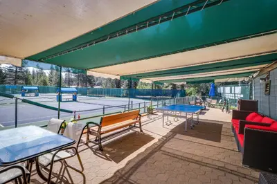 a tennis court with several tables and benches on a tennis court at Serventi Tahoe Donner Cabin in Truckee