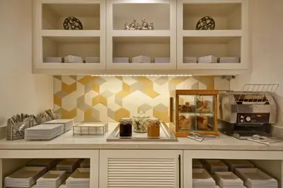 a kitchen with white cabinets and a counter with plates at Hyatt Place Fresno in Fresno