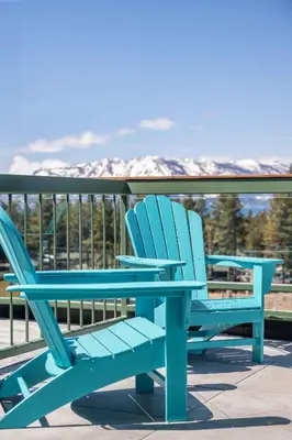 two blue chairs sitting on a deck with mountains in the background at Margaritaville Resort Lake Tahoe in South Lake Tahoe