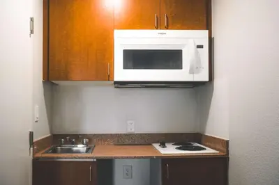 a small kitchen with a microwave and a sink at Studio 6 Rancho Cordova, CA in Rancho Cordova