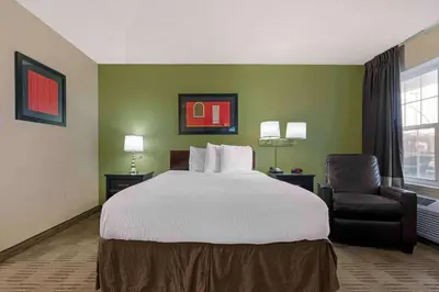 a hotel room with a bed and a chair at Extended Stay America Suites - Sacramento - Arden Way in Sacramento