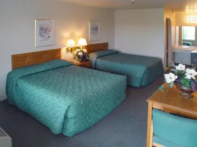 a hotel room with two beds and a table at Applegate Inn in Atwater