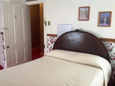 a bed with a wooden headboard in a bedroom at Bridgeport Inn in Bridgeport