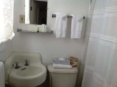 a bathroom with a sink and a toilet and a mirror at Bridgeport Inn in Bridgeport