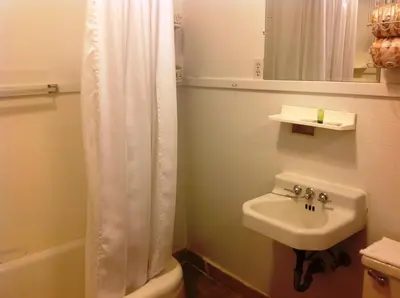 a bathroom with a shower curtain and a sink at Bridgeport Inn in Bridgeport