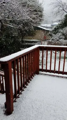 a wooden railing with snow on it at Becky's Condo in Mariposa