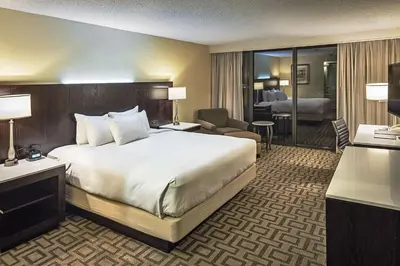 a hotel room with a large bed and a living room at Hilton Sacramento Arden West in Sacramento