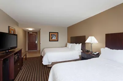 a hotel room with two beds and a flat screen tv at Hampton Inn & Suites Fresno - Northwest in Herndon