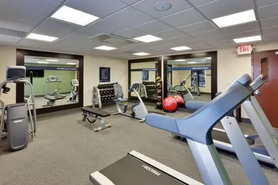 a gym with treadmills and exercise equipment and mirrors at Hampton Inn & Suites Fresno - Northwest in Herndon